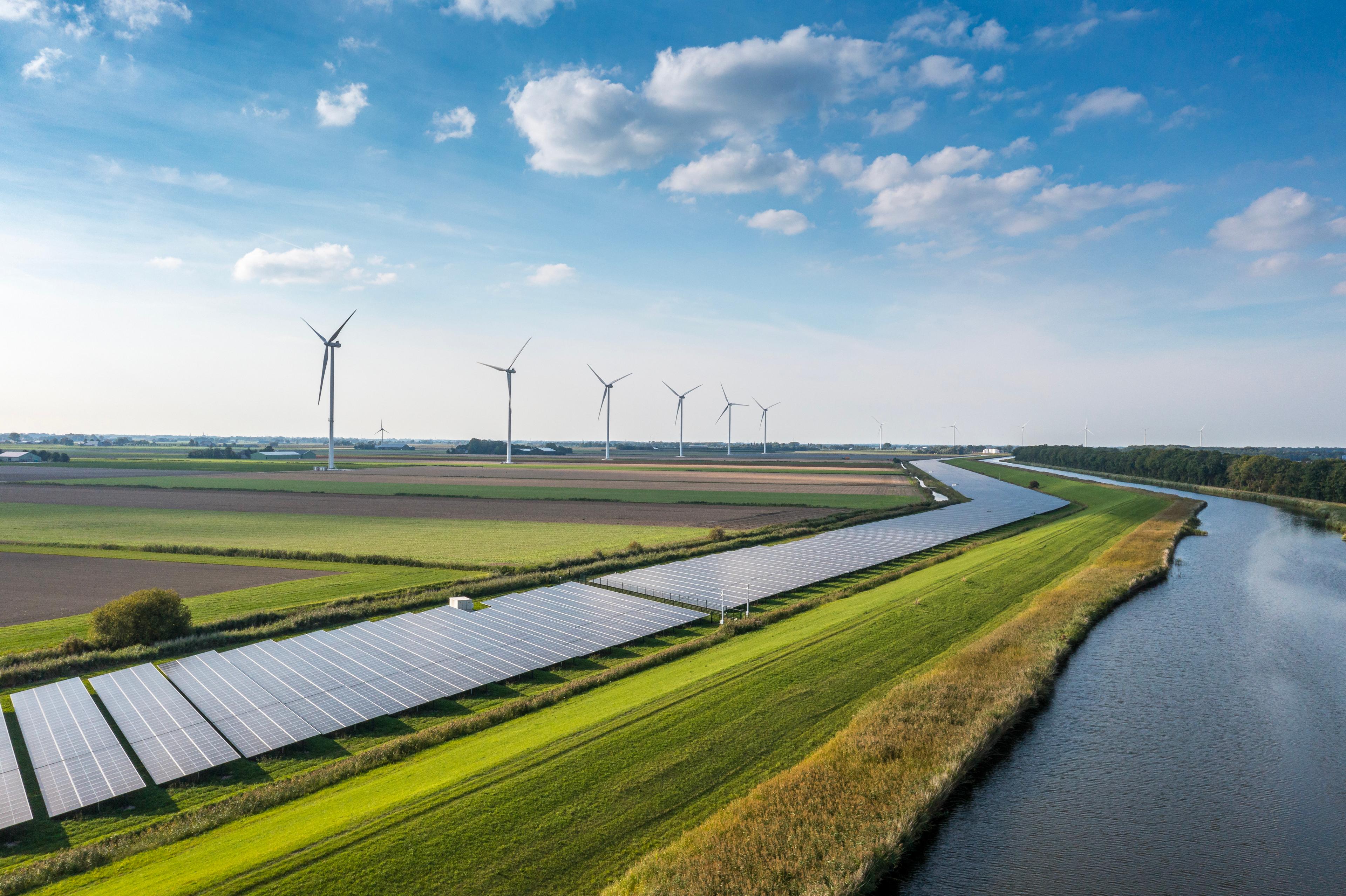 Landscape view of electric panels and wind turbine energy farm