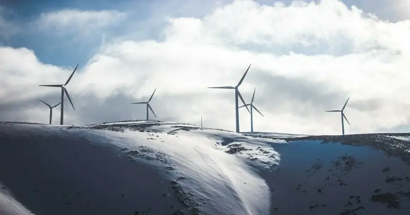 Windmill turbines on a snowy hill