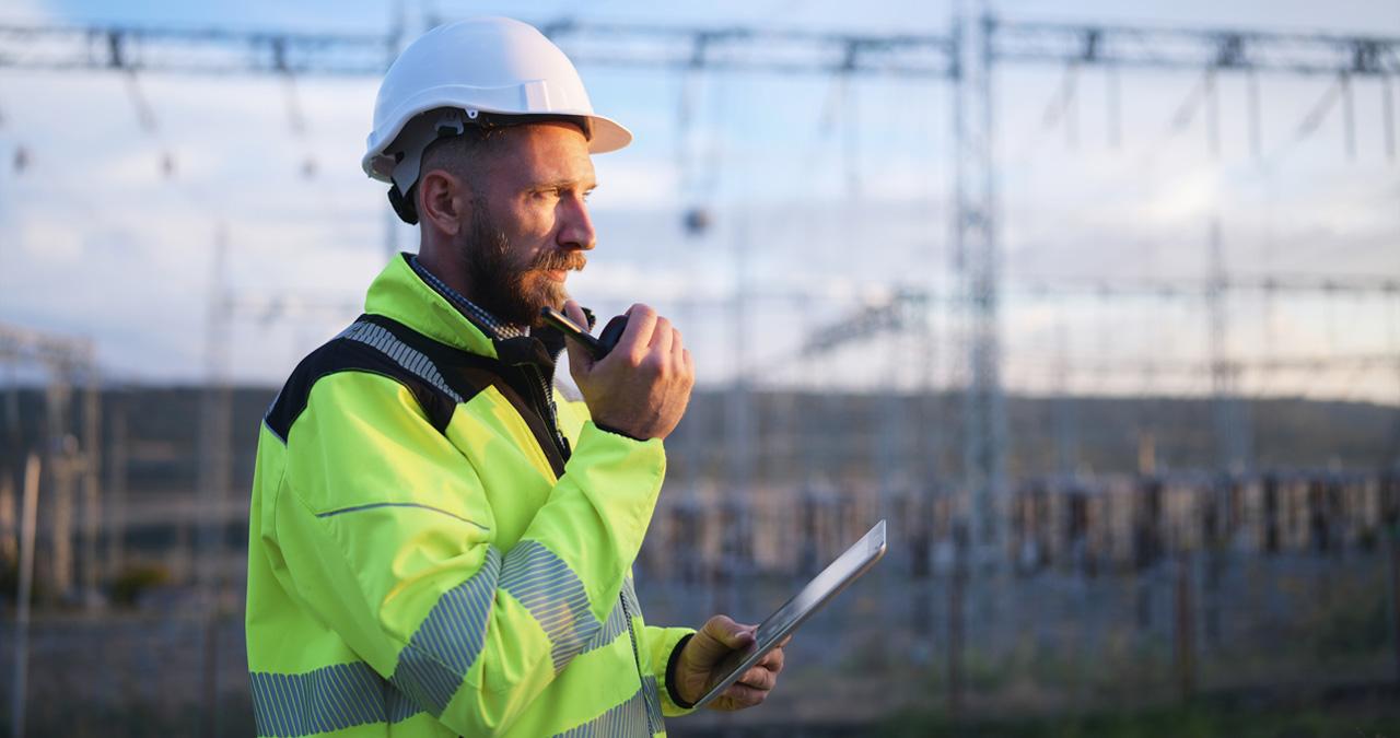 Image of a man working with power grid in the back to illustrate power grid software