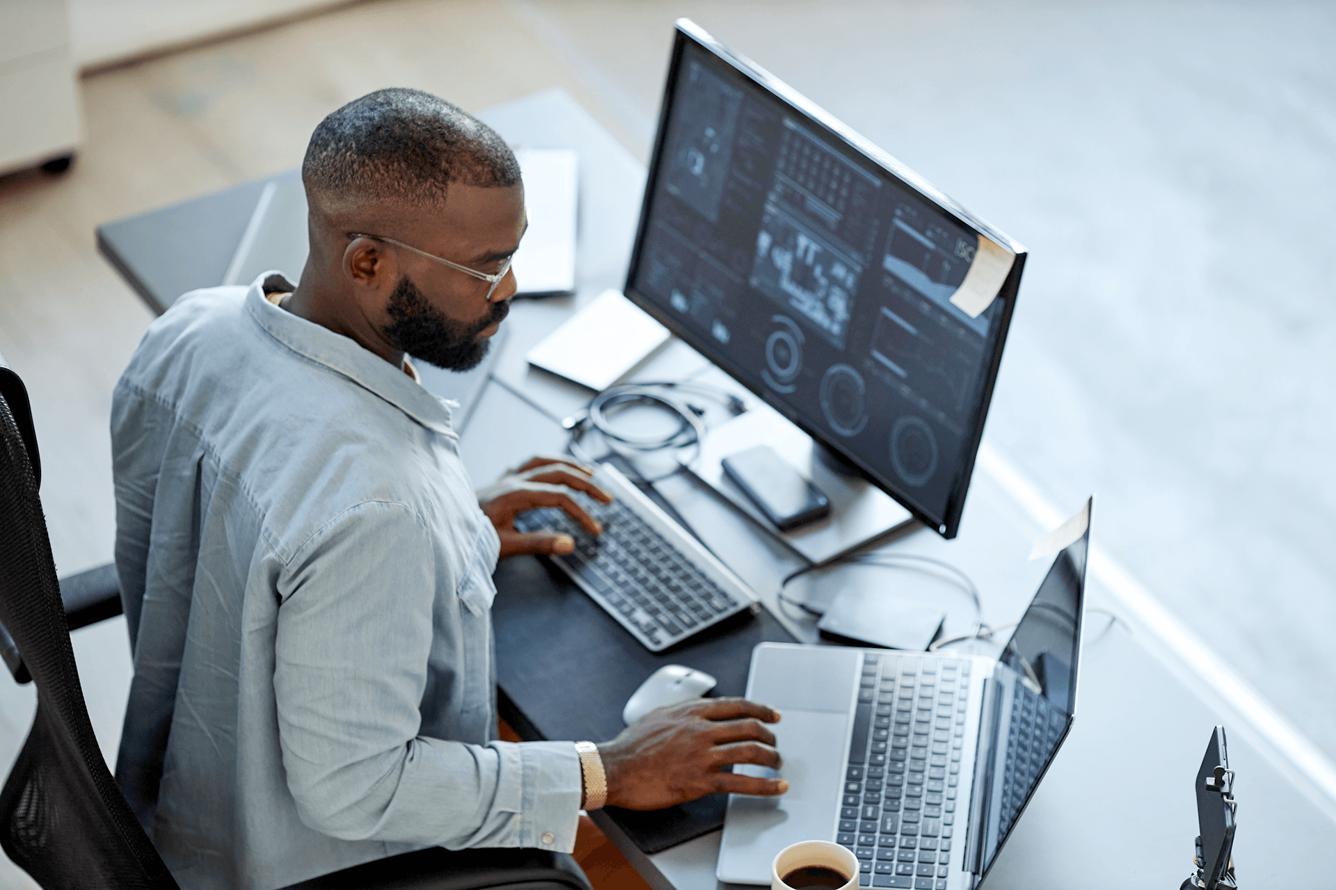 Image of a man trading on two screens to represent Volue Algo Trader Navigator - Trading Auto Pilot