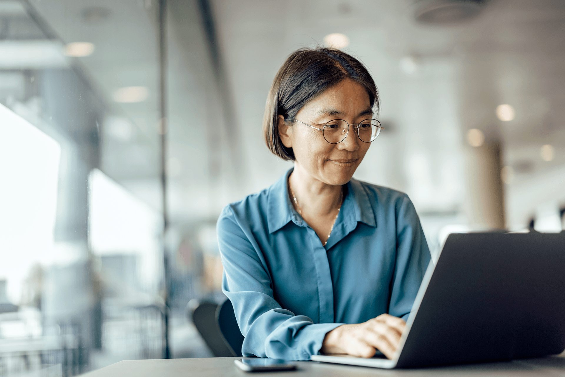 Image of a smiling woman in front of a laptop to represent Thedora Redispatch Service