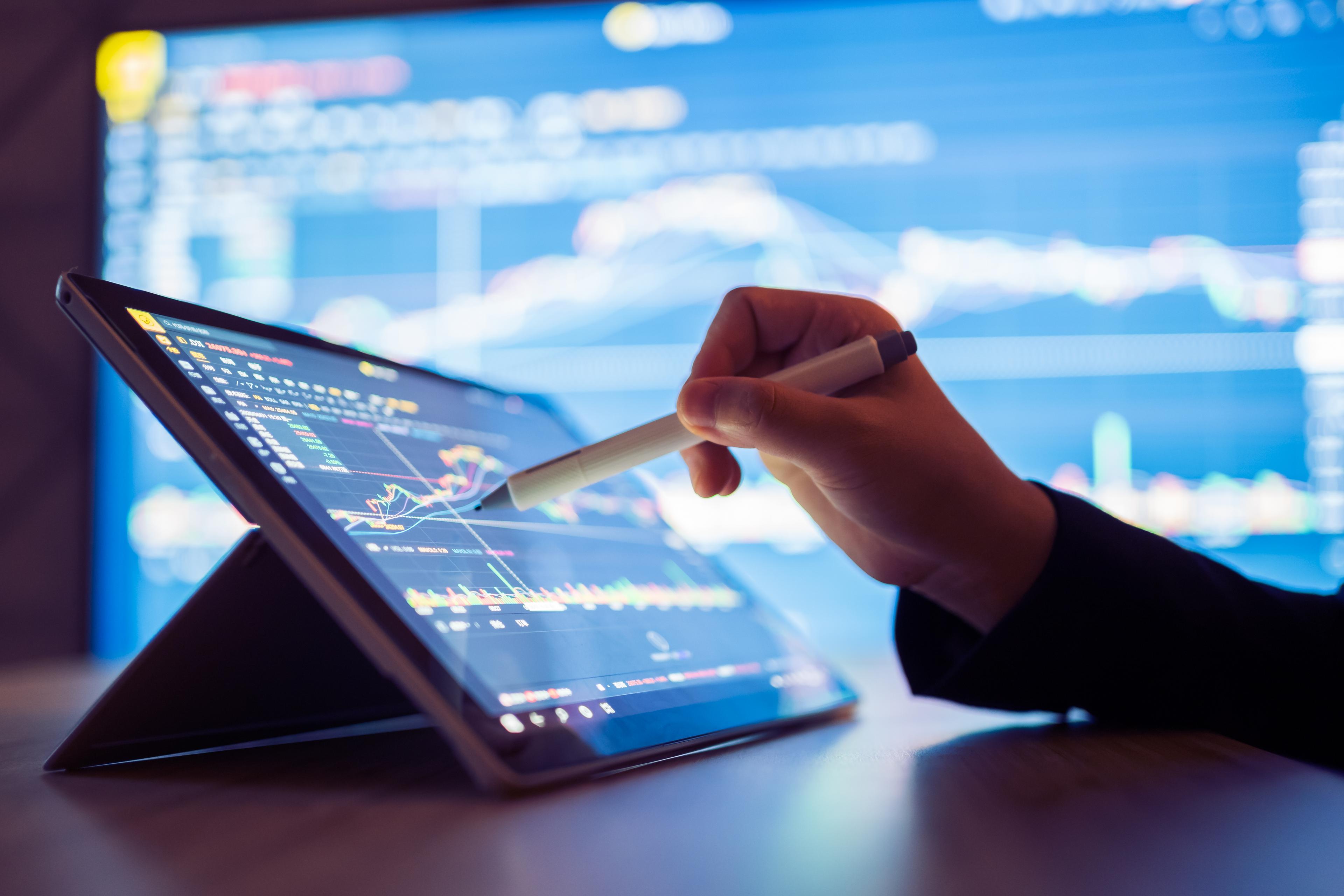 Person looking at stock market data on tablet