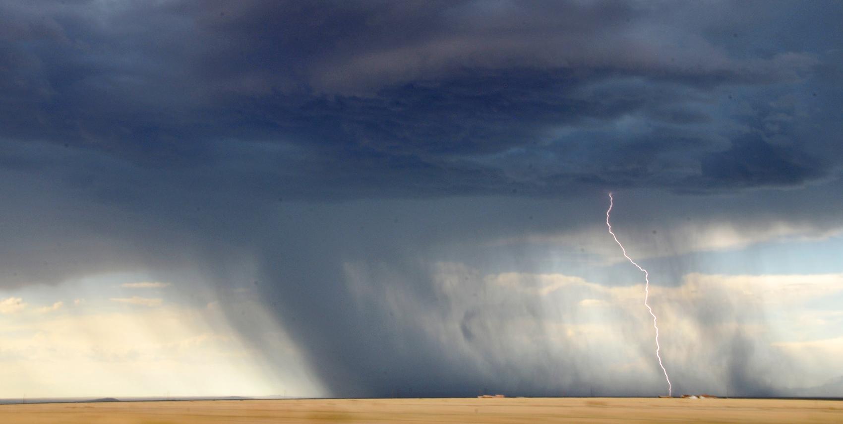 open landscape with lightning and dark clouds in the background