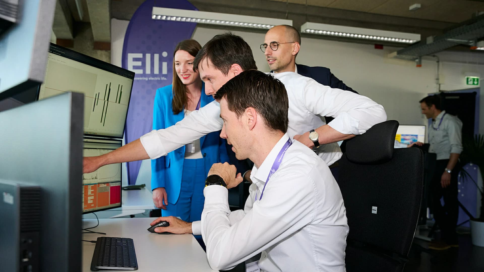 Employees discuss an analysis together at their desks