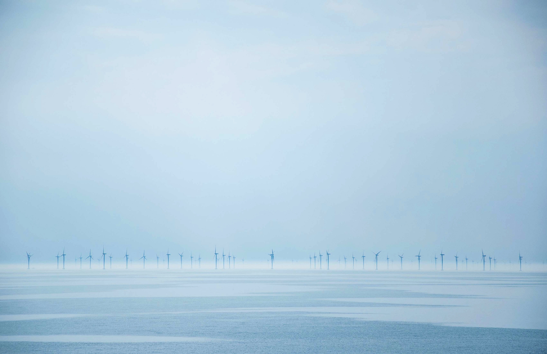Windmills in the ocean in winter time