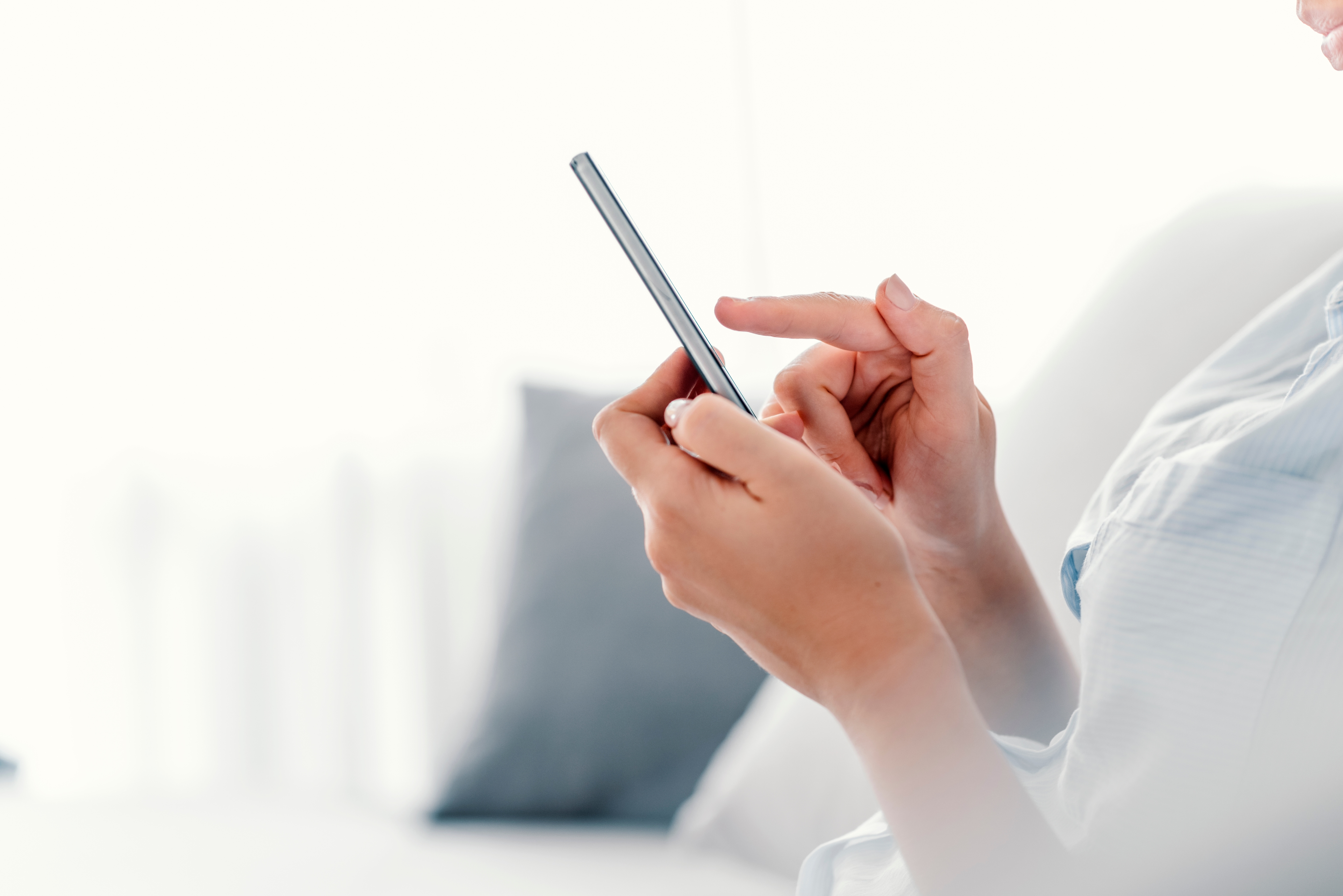 Woman with iPhone seen from the left side and no face showing